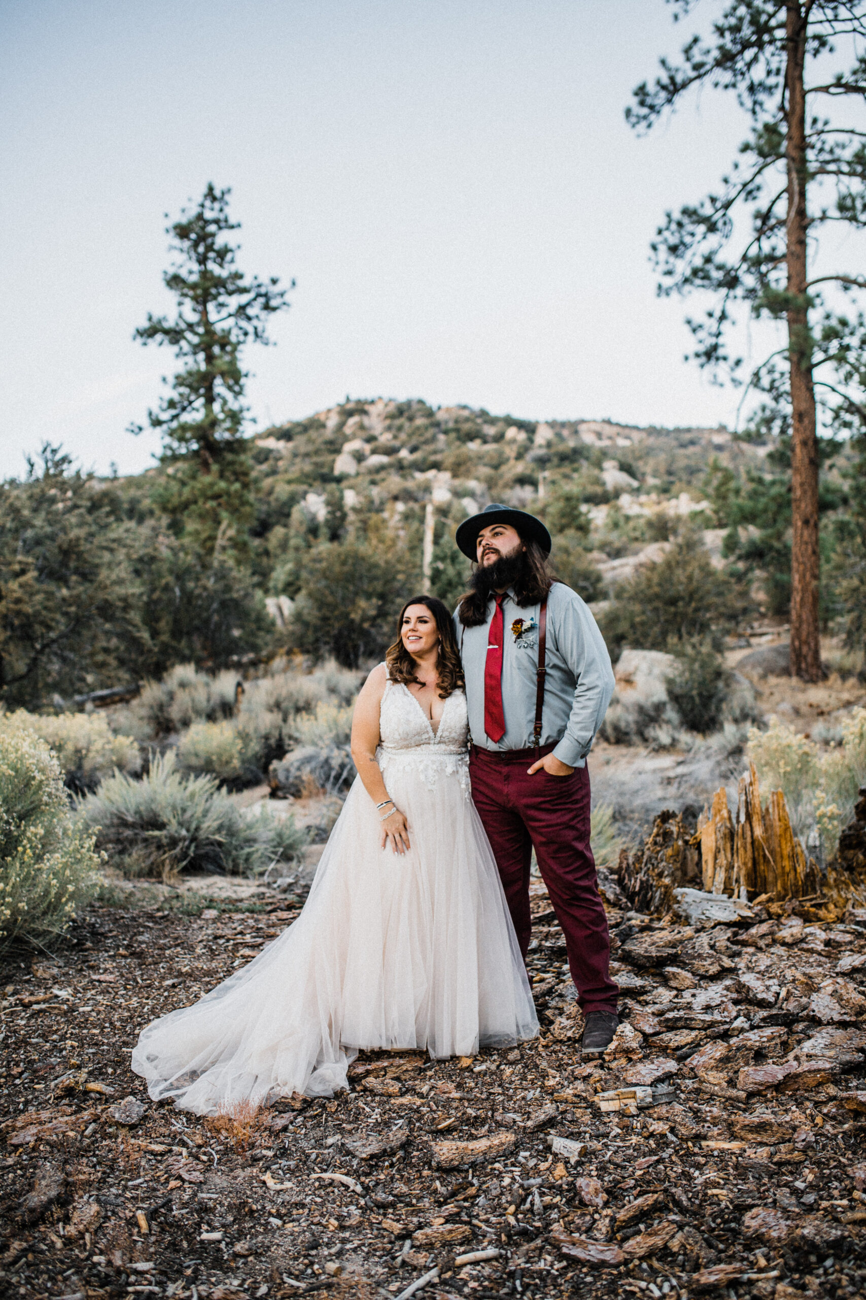 Smiling couple in forest elopement with champagne a-line style dress
