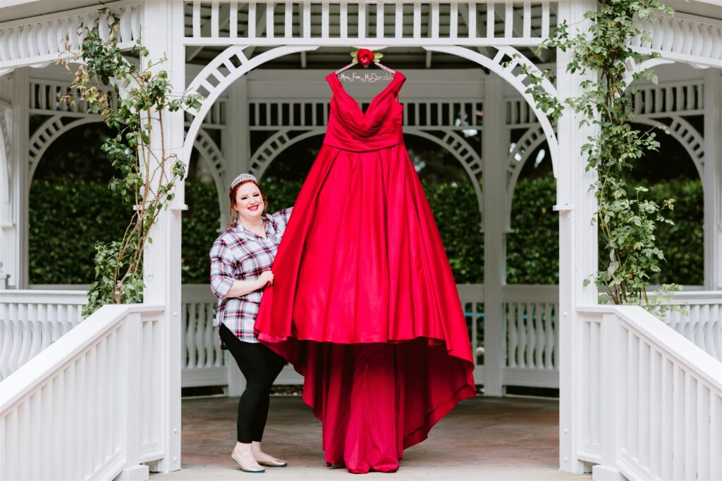bride showing off custom red wedding dress