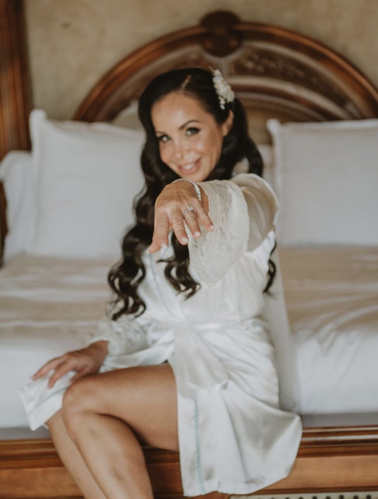 bride in satin bride robe showing off wedding ring