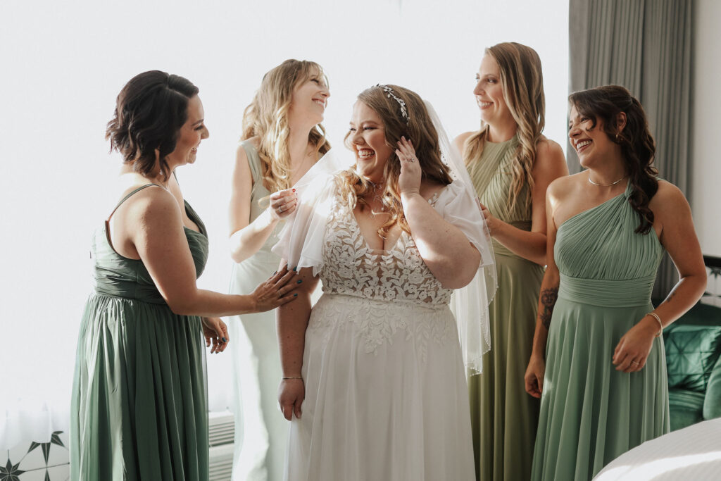 bridesmaids in green dresses looking at bride