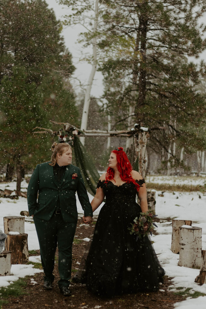 groom and plus size bride wearing black wedding dress in snow in northern arizona winter wedding
