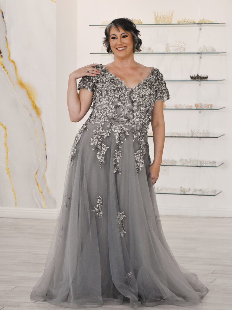 woman wearing formalwear gown with sleeves, in lace and tulle, for mother of the bride dress, in chandler arizona bridal shop