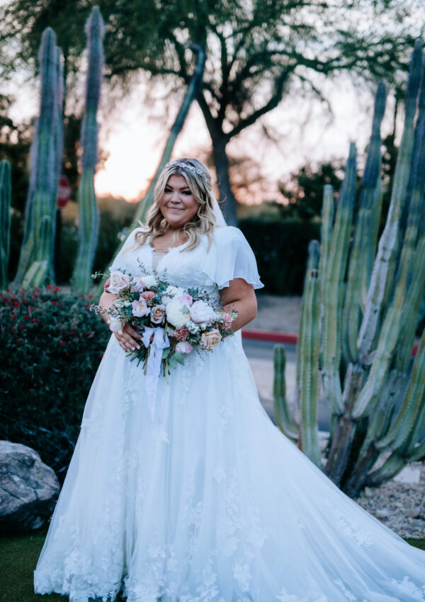 bride wearing modest wedding dress with sleeves in front of mormon temple in mesa arizona